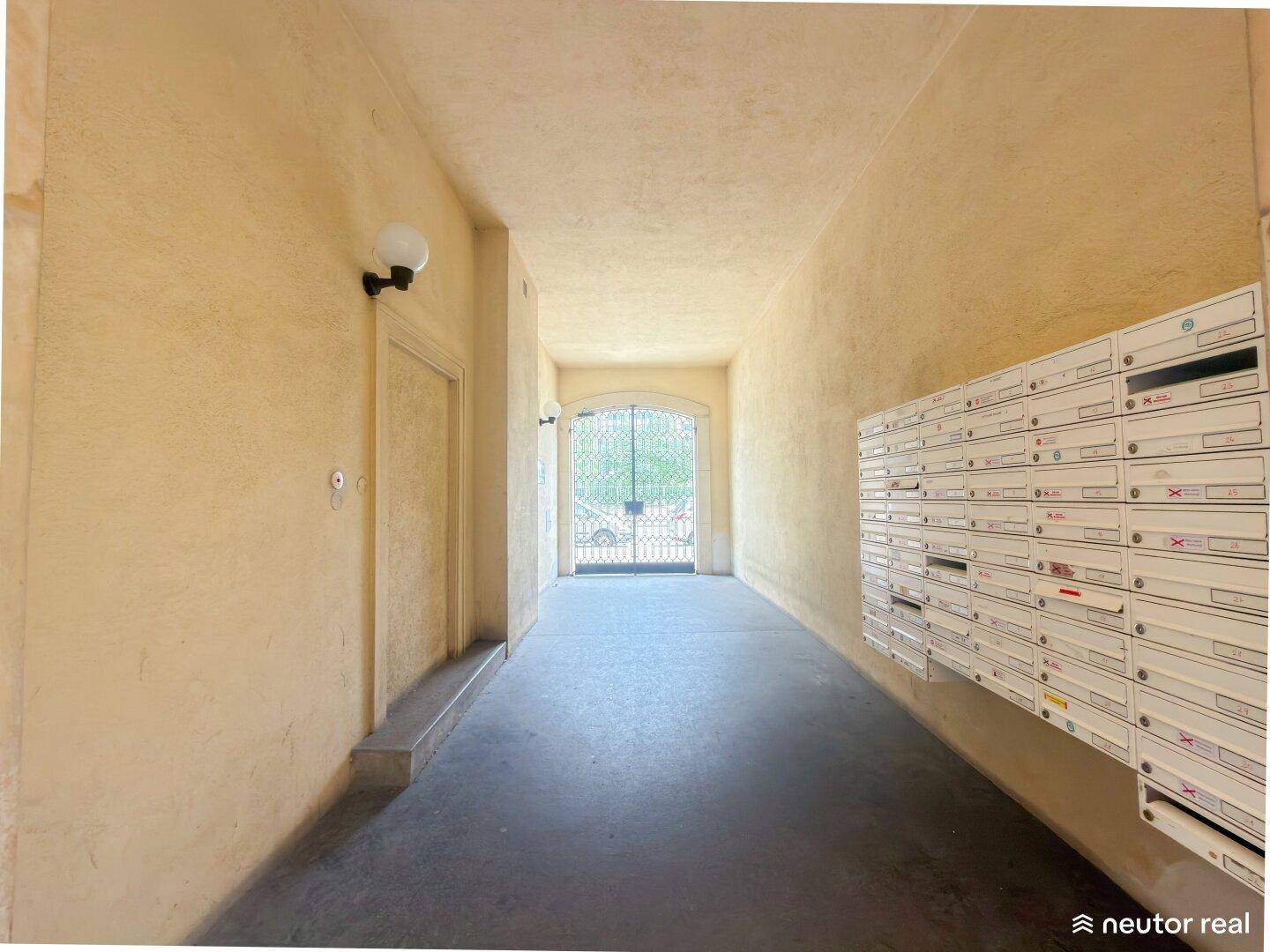 Langer Flur im Eingangsbereich mit Briefkästen und Blick zum Hoftor.