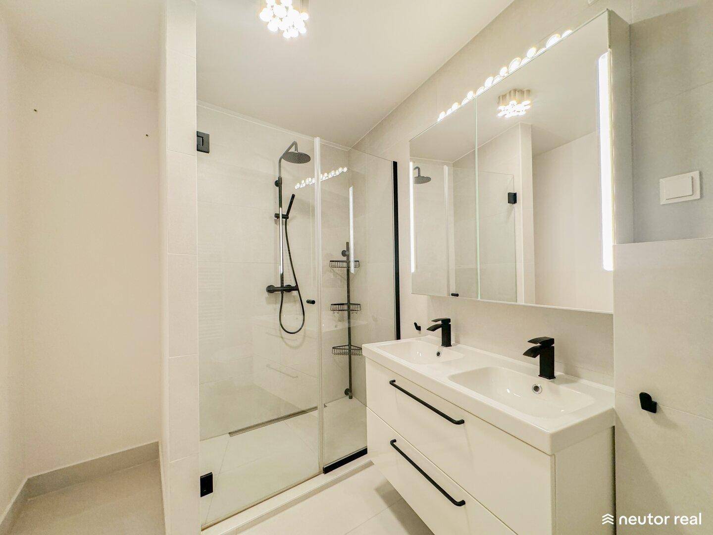 Modernes Badezimmer mit begehbarer Dusche, Doppelwaschbecken und stilvollen schwarzen Armaturen.