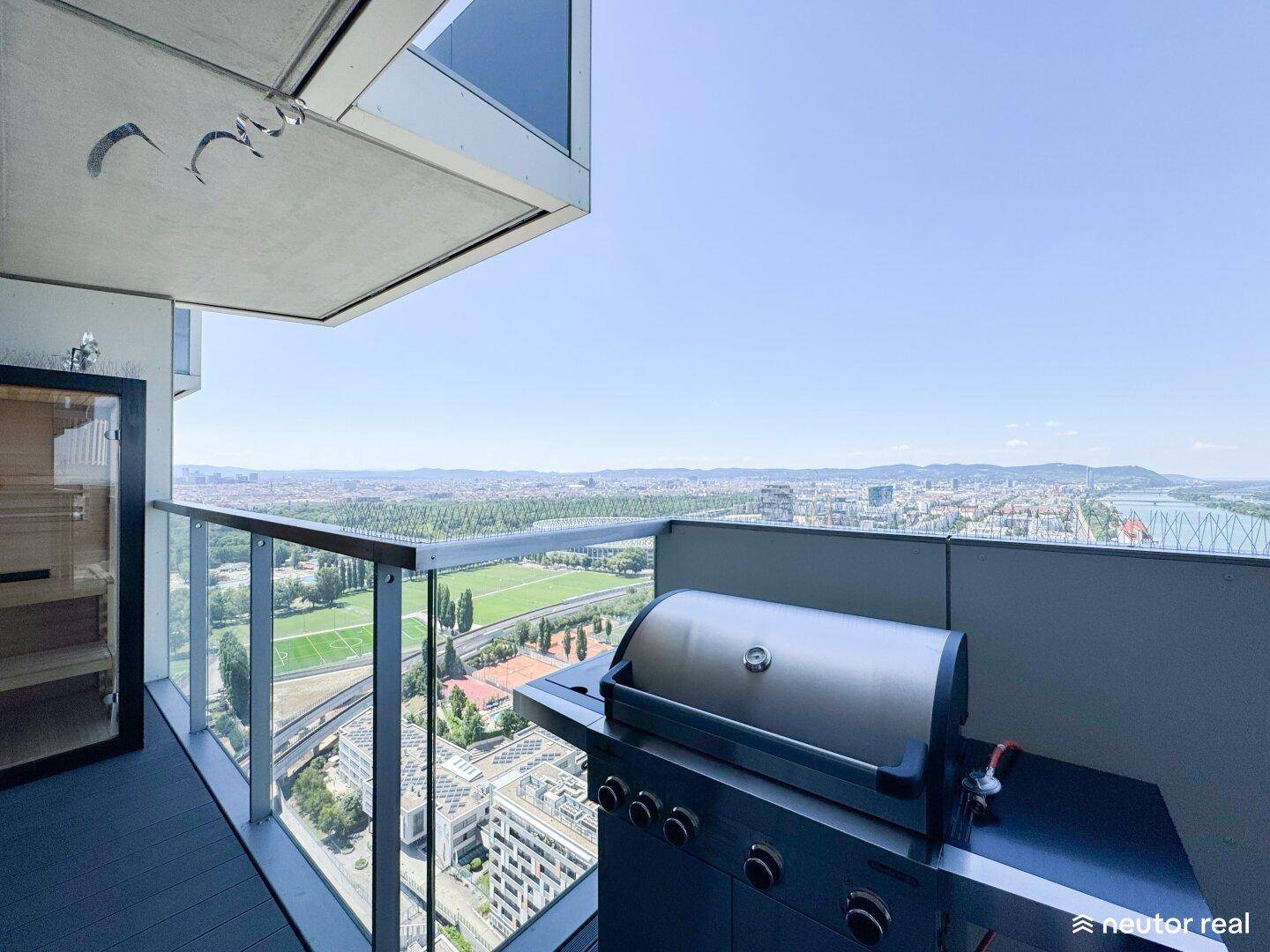 Großer Balkon mit Gasgrill, Außensauna und weitem Blick über die Stadt und den Fluss.