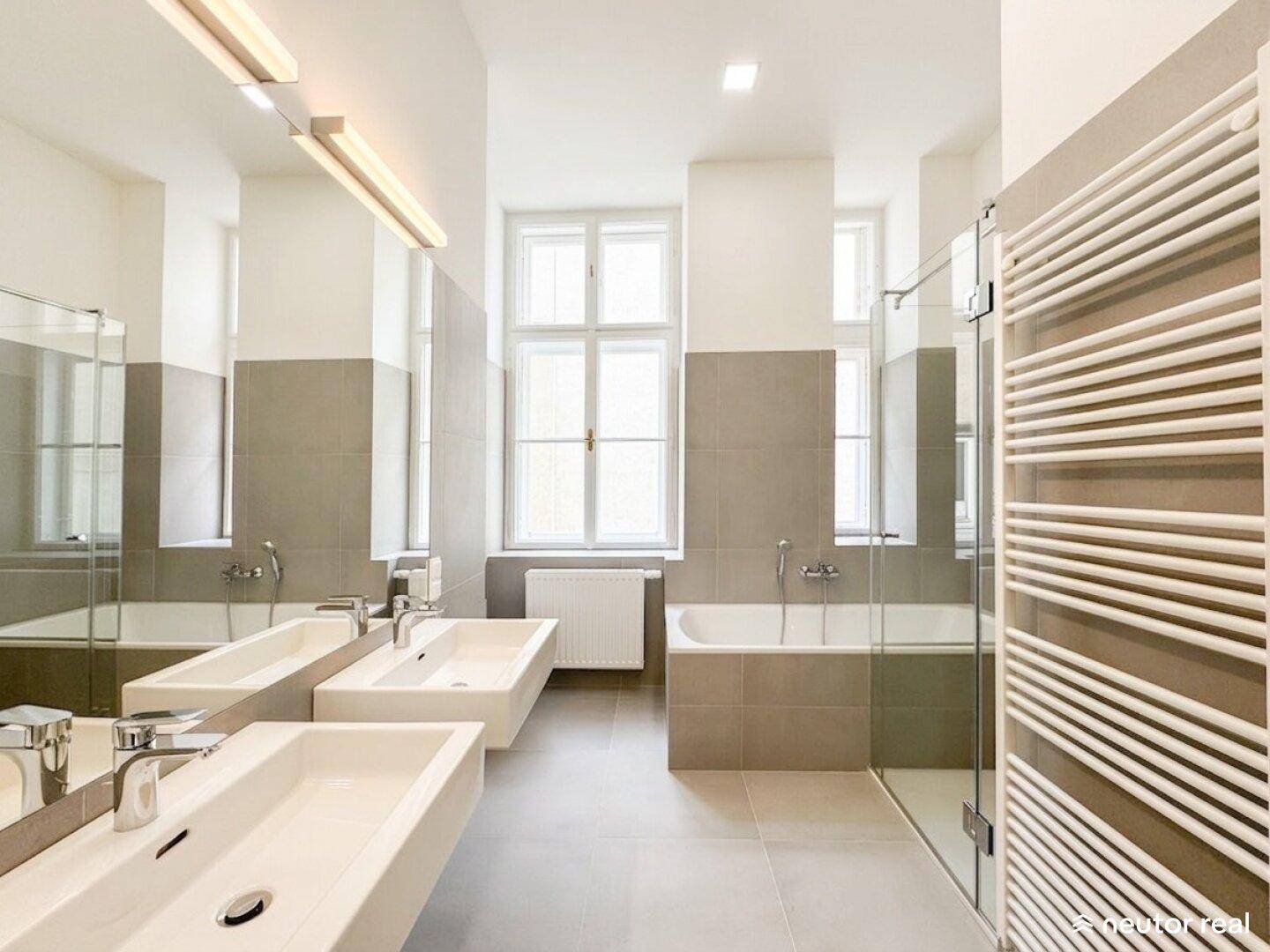 Modernes Badezimmer mit Doppelwaschbecken, Badewanne, Dusche und beheiztem Handtuchhalter.