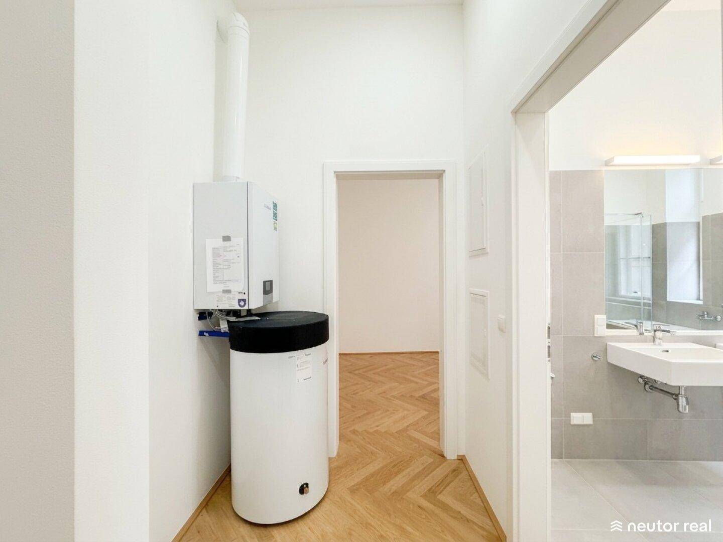 Flur mit Heizungsanlage und direktem Zugang zu einem modernen Badezimmer.