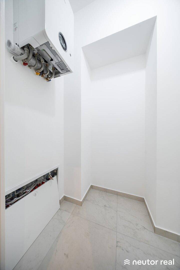 Kleiner Hauswirtschaftsraum mit Gastherme und Anschlüssen, ideal für Technik und Lagerung.