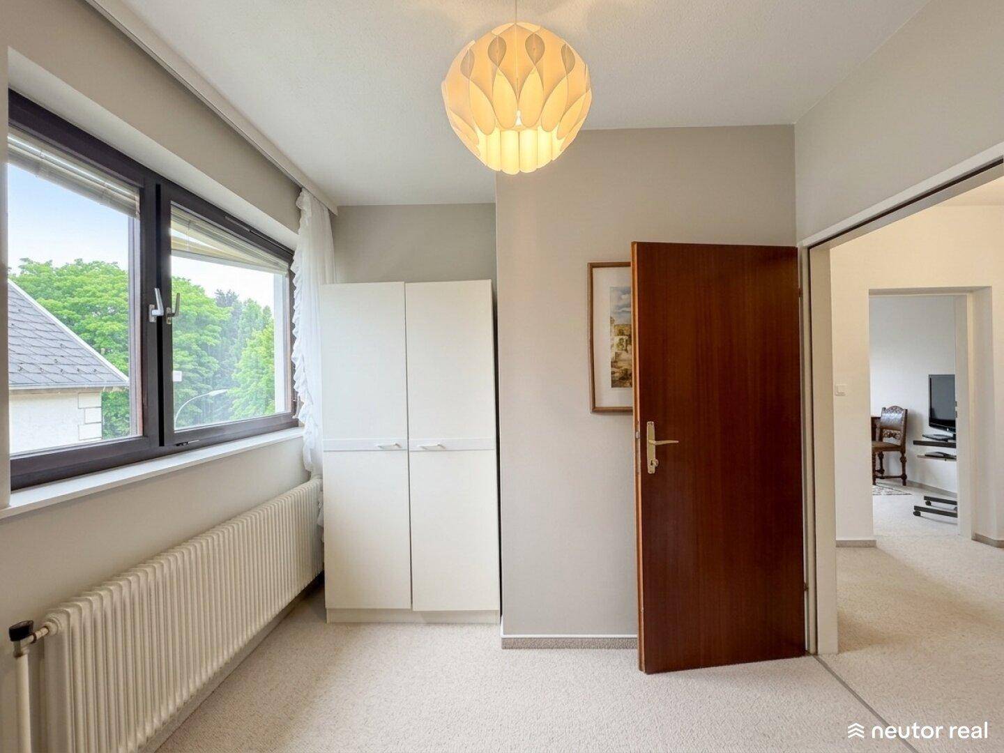 Flur mit Fenster, Einbauschrank und Zugang zu weiteren Räumen.