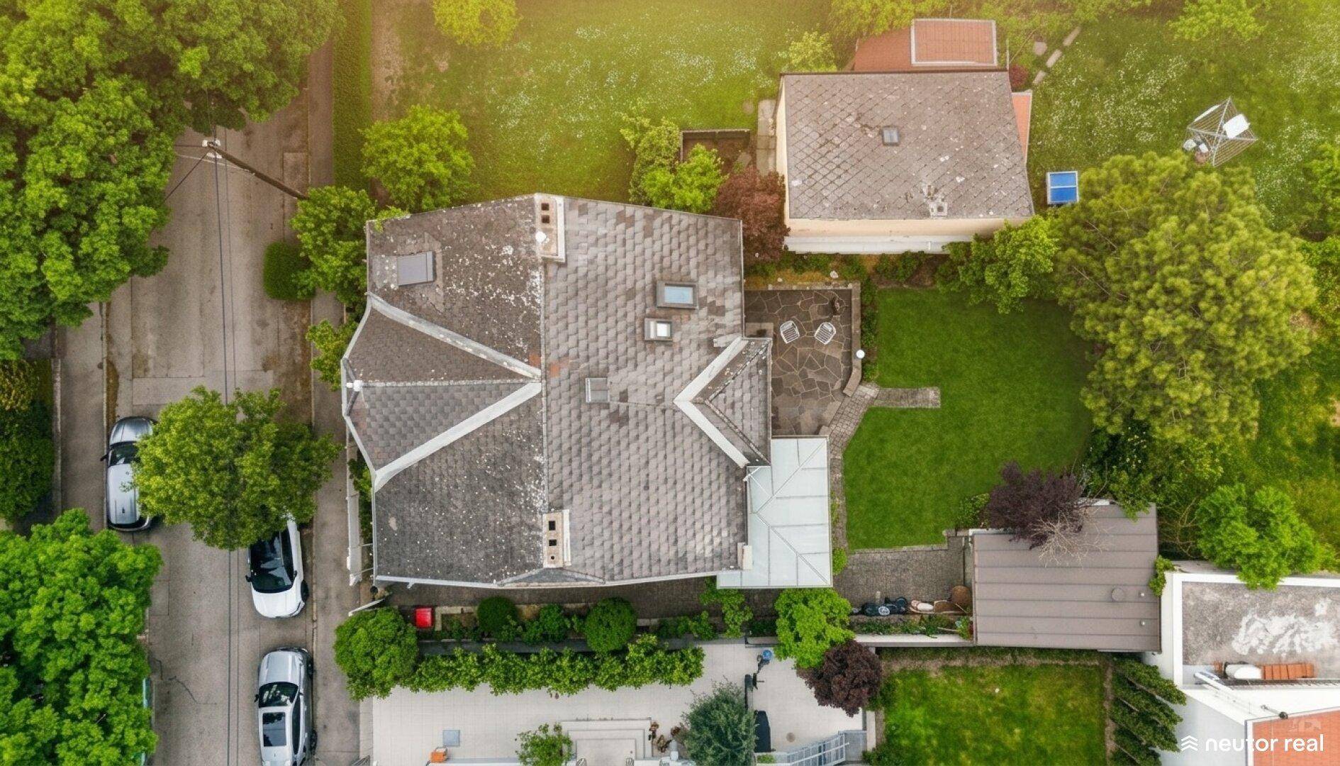 Vogelperspektive des Grundstücks mit Haus, Garten und umliegender Bebauung.
