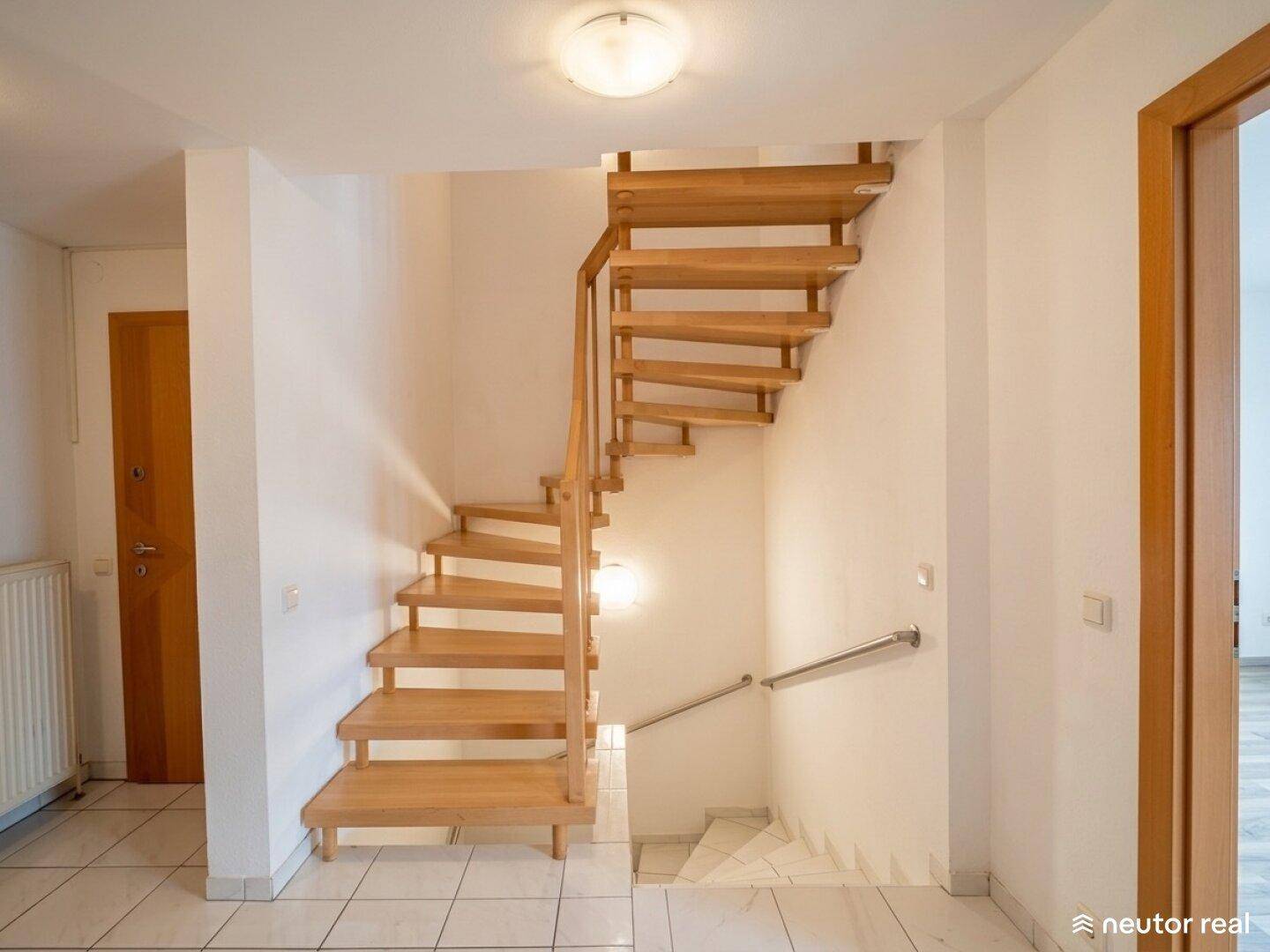 Helle Holztreppe im Flur, die die verschiedenen Etagen des Hauses verbindet.