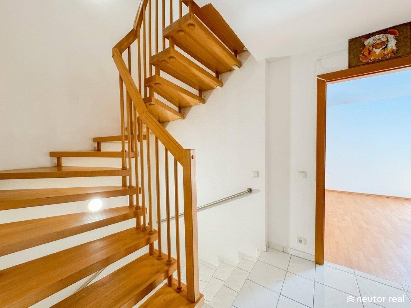 Robuste Holztreppe mit Geländer, die zu den oberen Stockwerken führt.