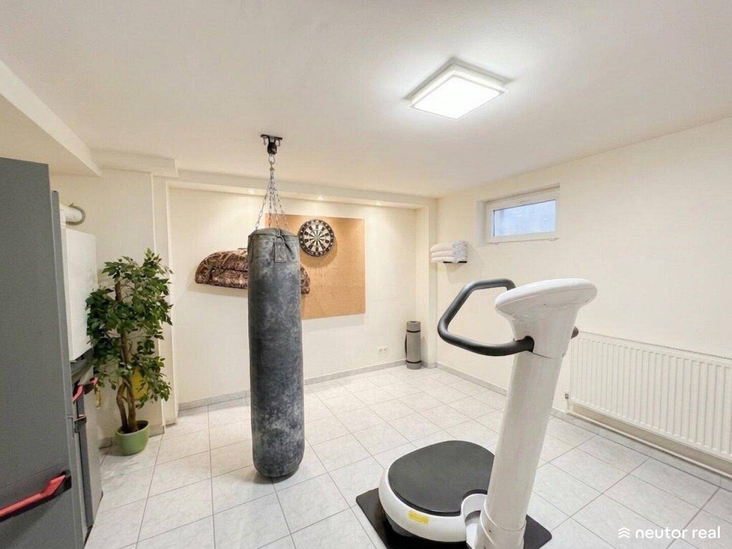Geräumiger Raum im Untergeschoss, ausgestattet als Fitnessbereich mit Sportgeräten.