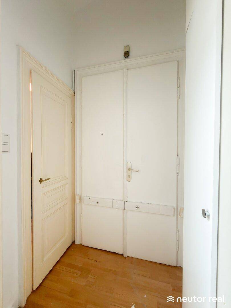 Eingangsbereich mit zwei Türen und Holzfußboden, der zu den weiteren Räumen führt.