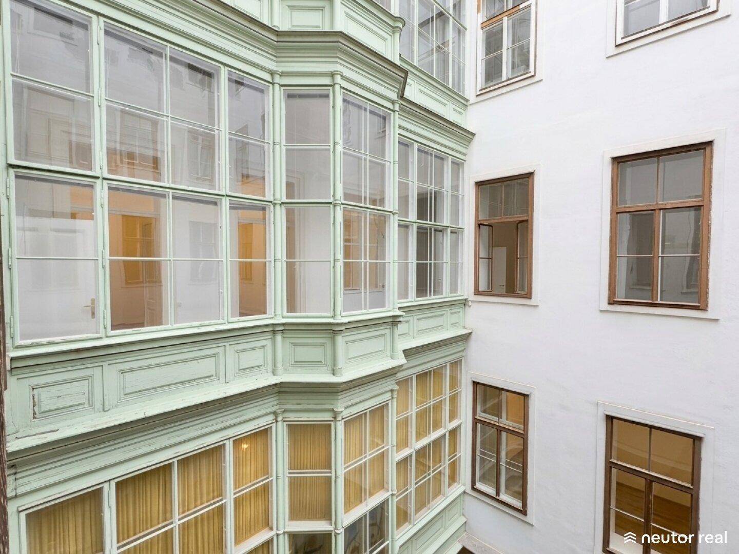 Detailansicht eines historischen Gebäudes mit Erkern und vielen Fenstern.