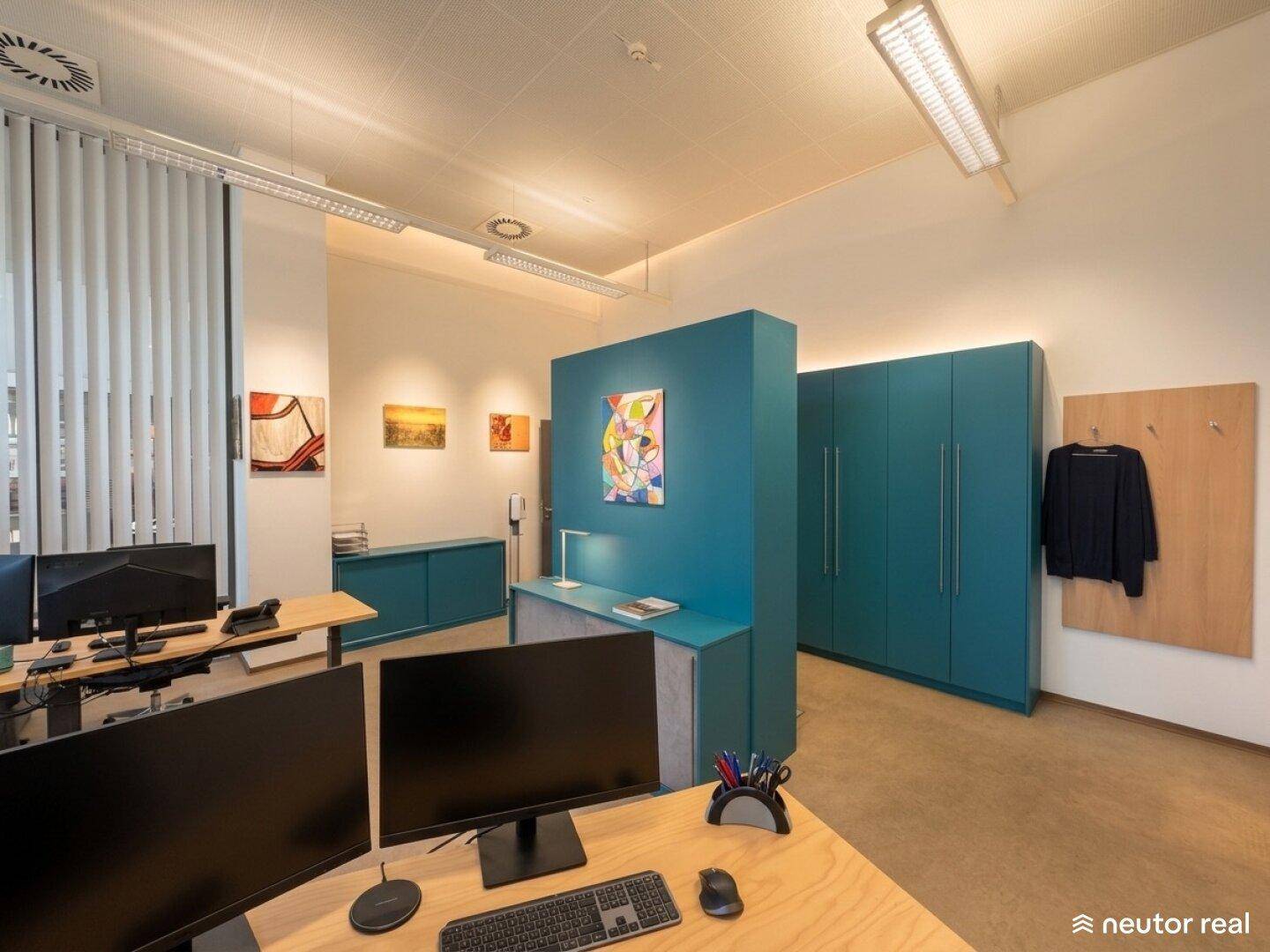 Modern gestalteter Bürobereich mit farbigen Akzenten, Schränken und mehreren Arbeitsplätzen.