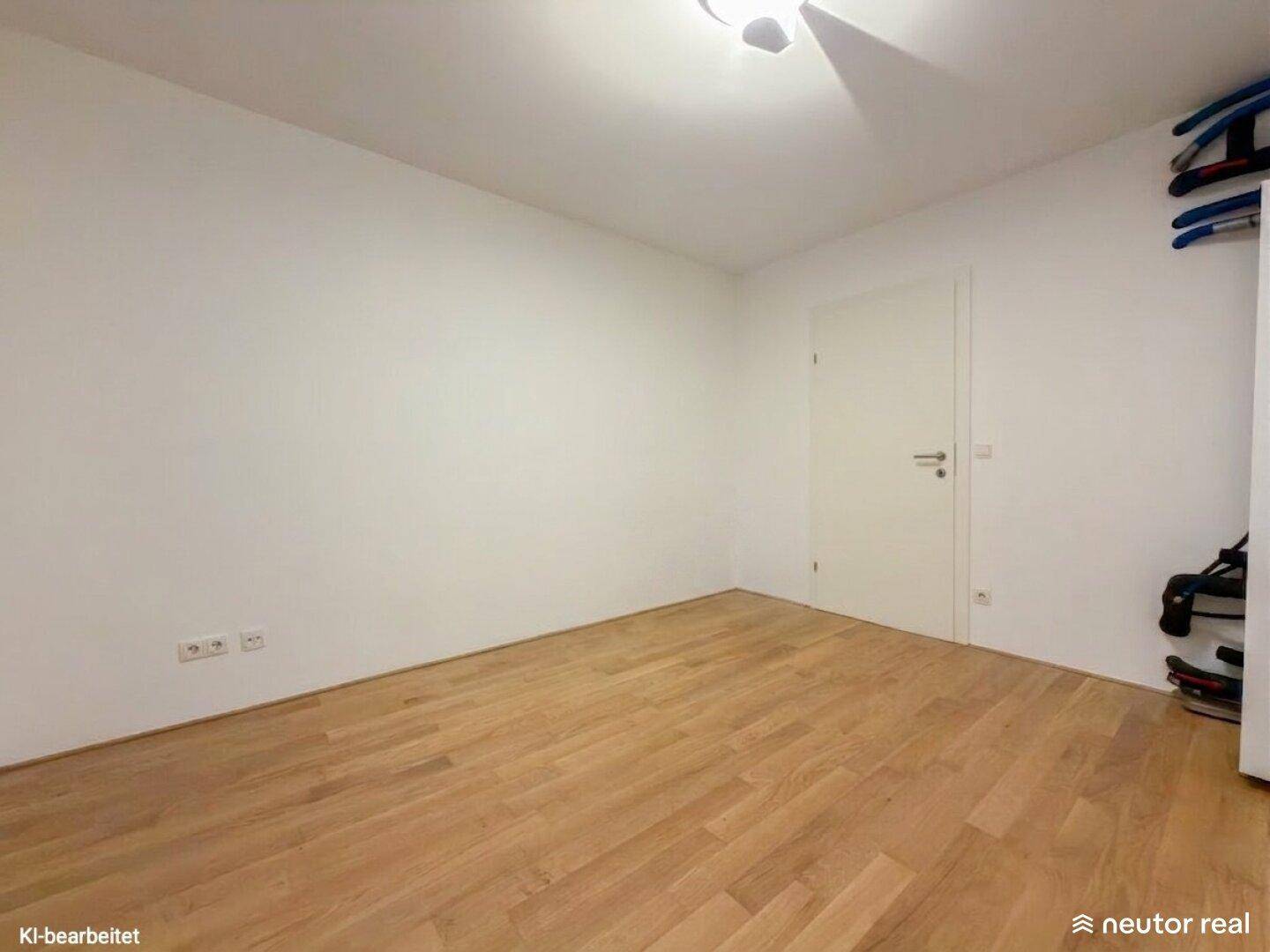 Helles, leeres Zimmer mit Holzboden und weiß gestrichenen Wänden, bereit zur individuellen Gestaltung.