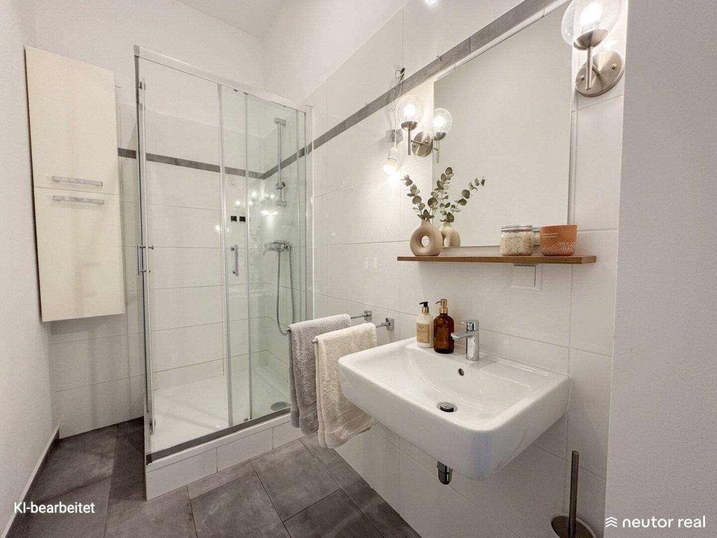 Modernes Badezimmer mit Duschkabine, Wandwaschbecken und hellen Fliesen.