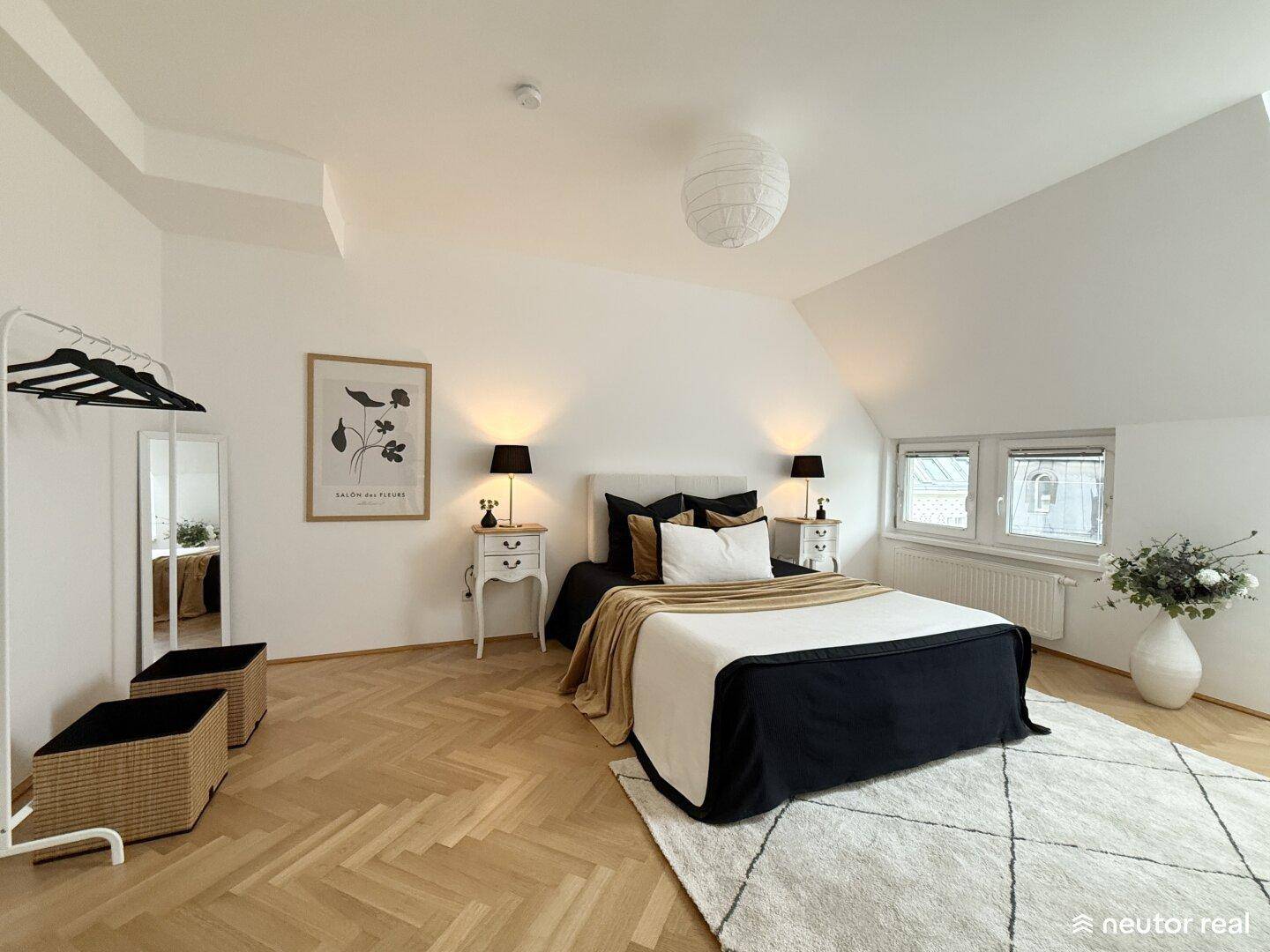 Helles Schlafzimmer mit Fischgrätparkett, Dachschrägen und moderner Einrichtung im Dachgeschoss.
