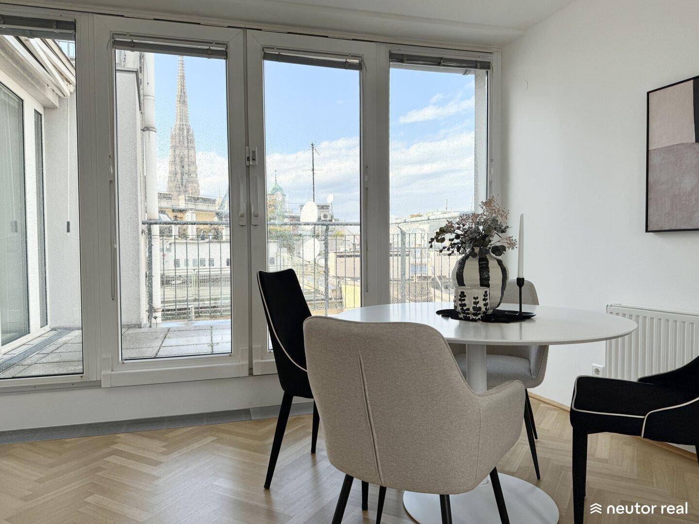 Essbereich mit Stadtblick, großen Fenstern und Zugang zur Terrasse.