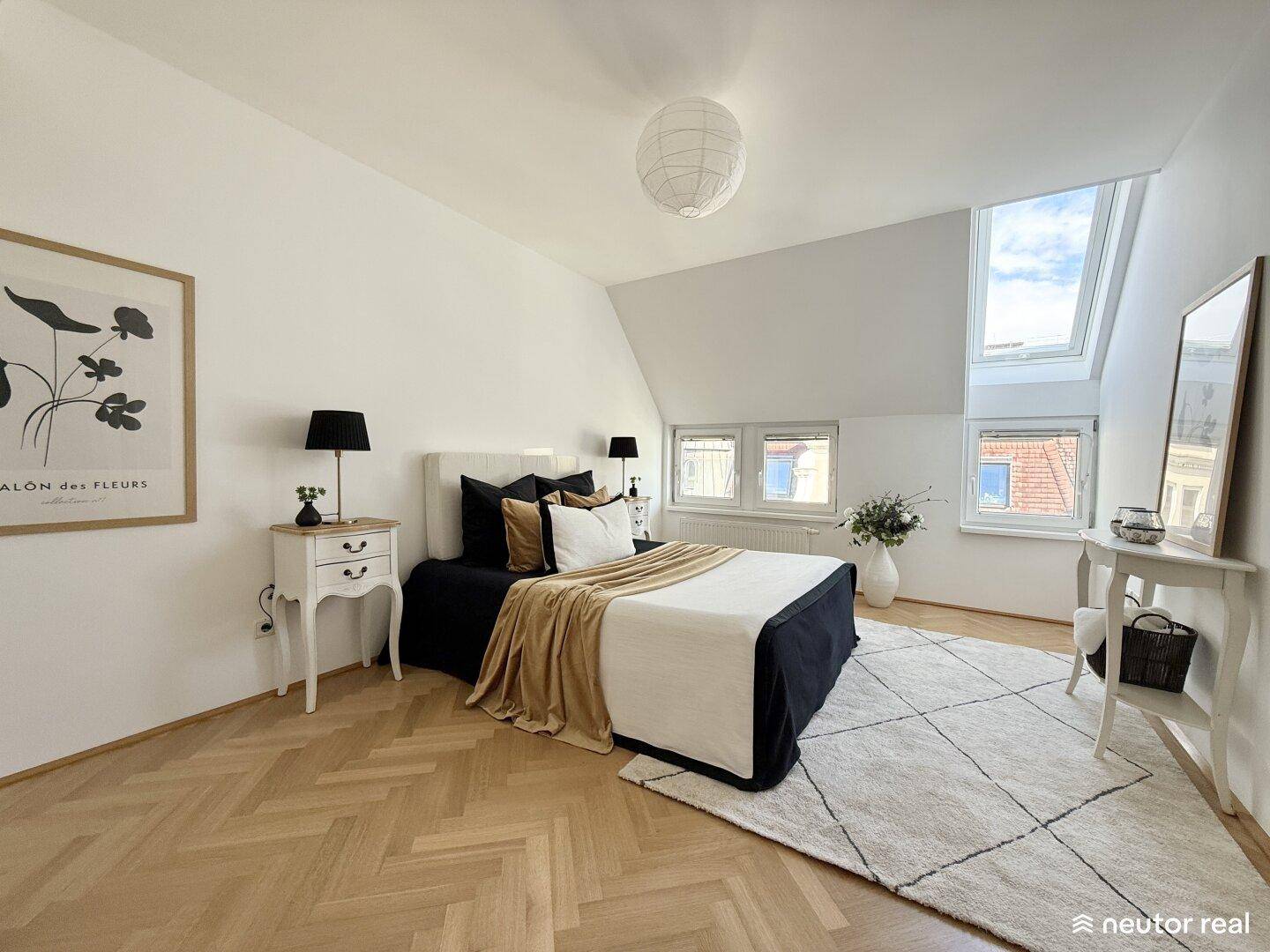 Geräumiges Schlafzimmer mit Fischgrätparkett, Dachschrägen und großen Fenstern für viel Licht.