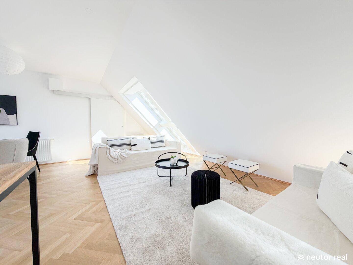 Heller Wohnbereich mit modernem Sofa, Dachschrägenfenster und Eichenparkett, ideal zum Entspannen.