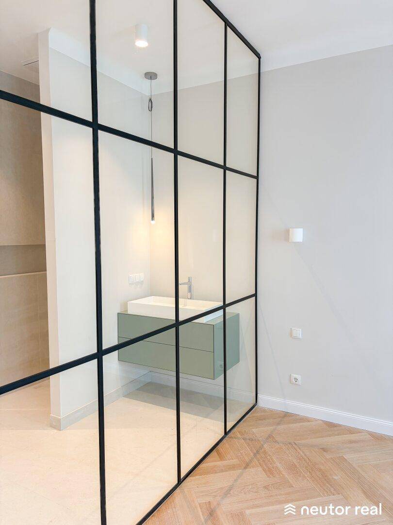 Moderner Waschtisch mit schwebendem Unterschrank hinter einer eleganten Glaswand im Badezimmer.