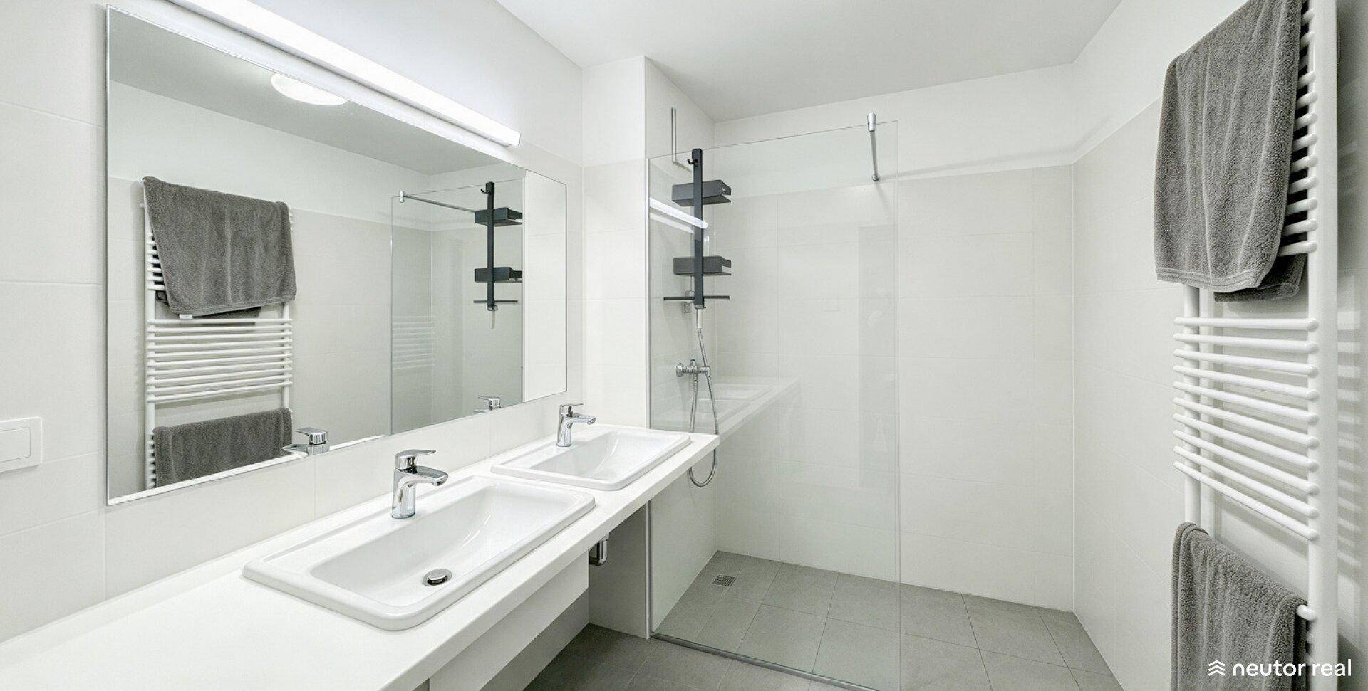 Modernes Badezimmer mit Doppelwaschbecken, großer Spiegelfläche und ebenerdiger Dusche.