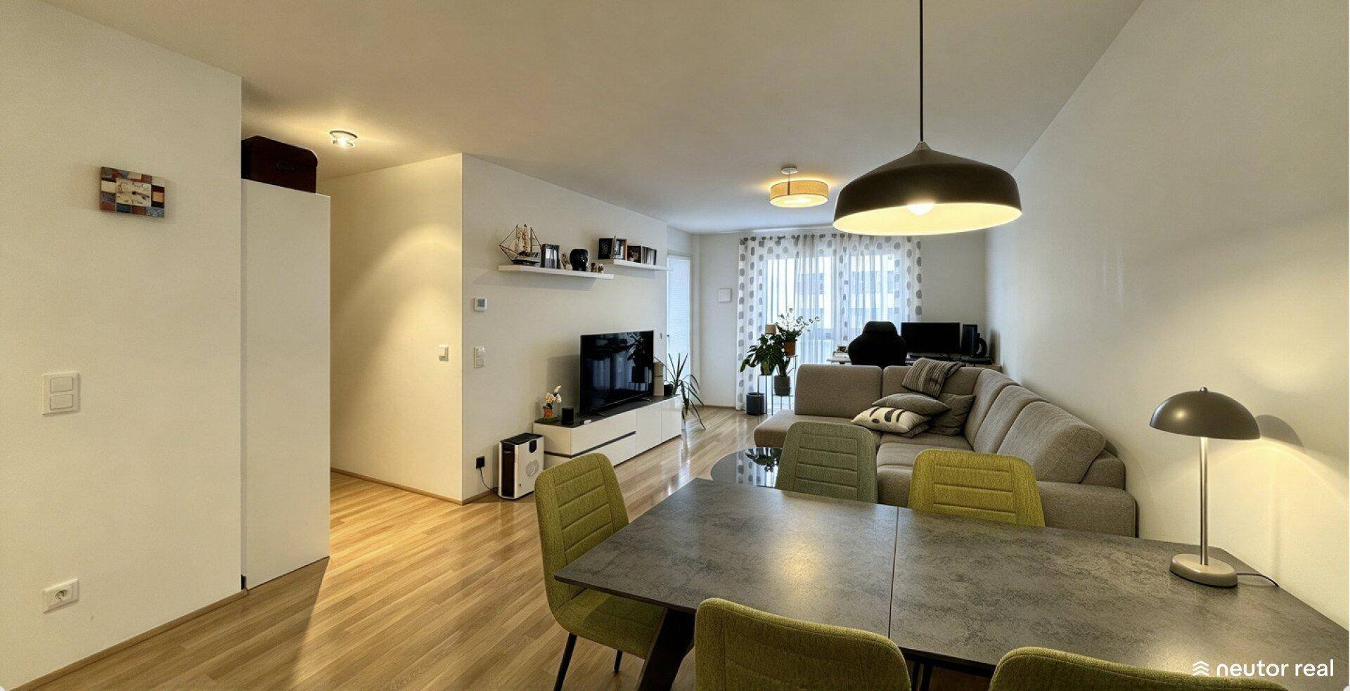 Heller Wohn-Essbereich mit beigem Ecksofa, Esstisch und Parkettboden in modernem Stil.