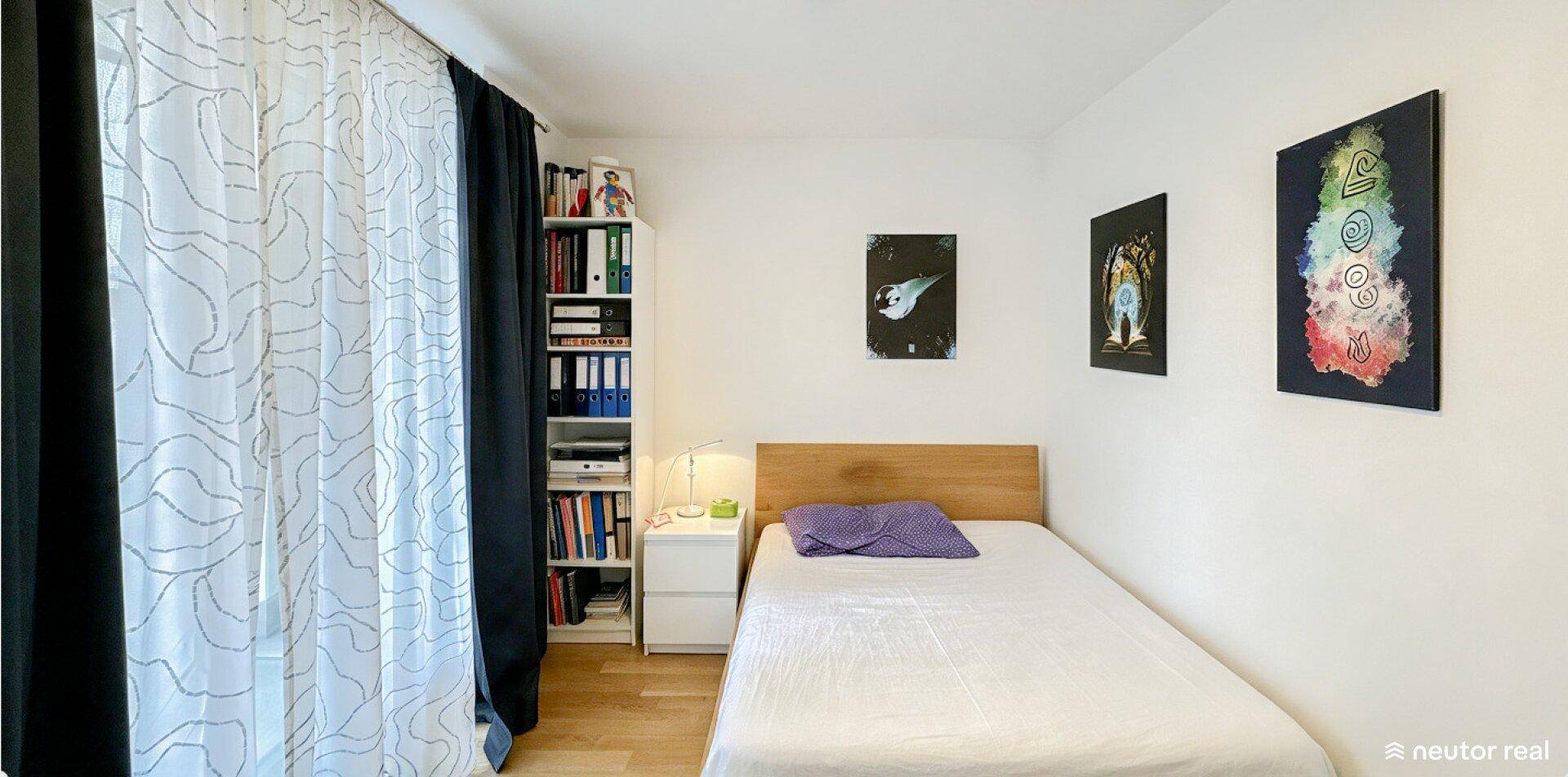 Gemütliches Schlafzimmer mit Einzelbett, Holzrahmen und Bücherregal neben dem Fenster.