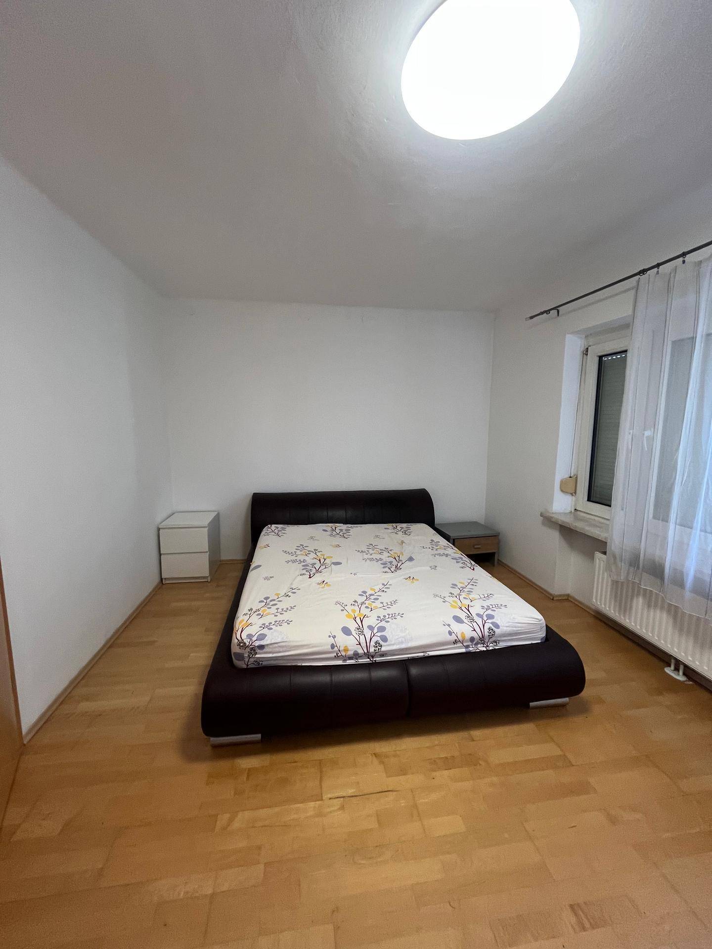 Schlafzimmer mit Doppelbett, Nachttischen und hellem Parkettboden.
