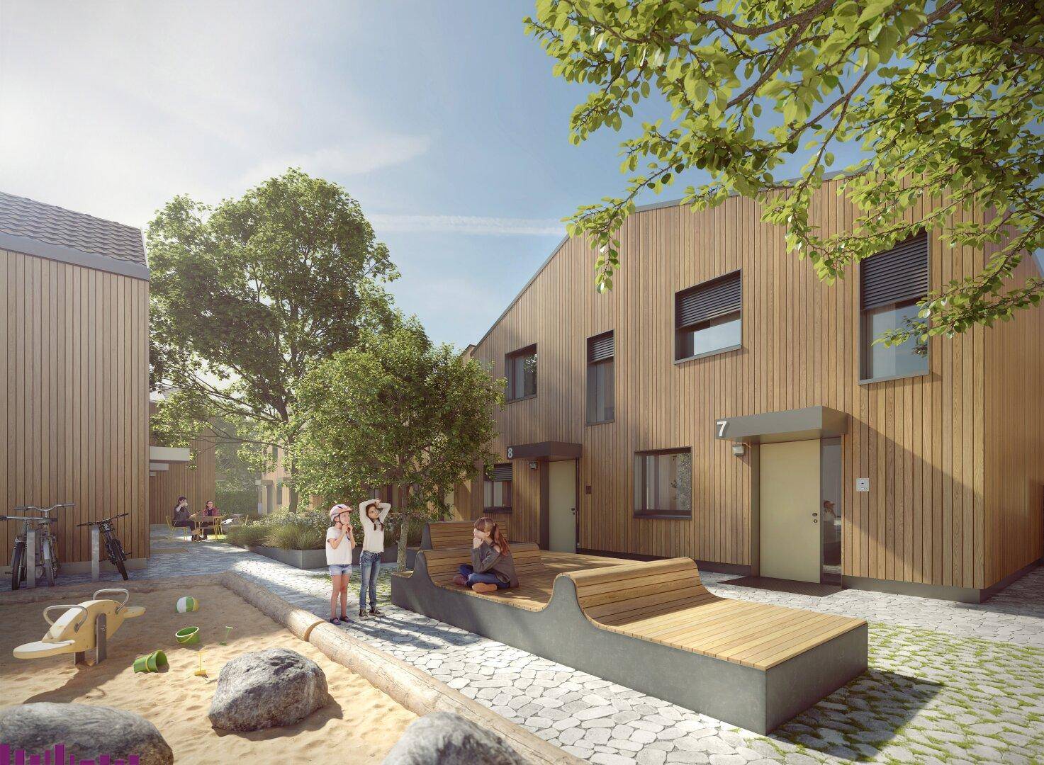 Moderne Reihenhäuser mit Holzfassade und einem gemeinschaftlichen Spielplatz im Freien.
