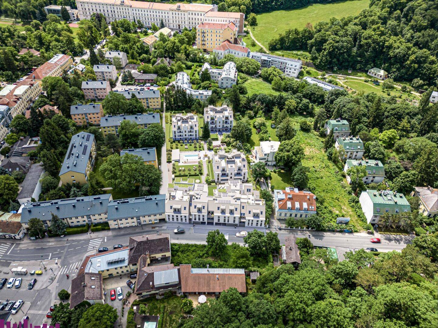 Luftaufnahme der Wohnanlage eingebettet in eine grüne Umgebung mit umliegenden Gebäuden.
