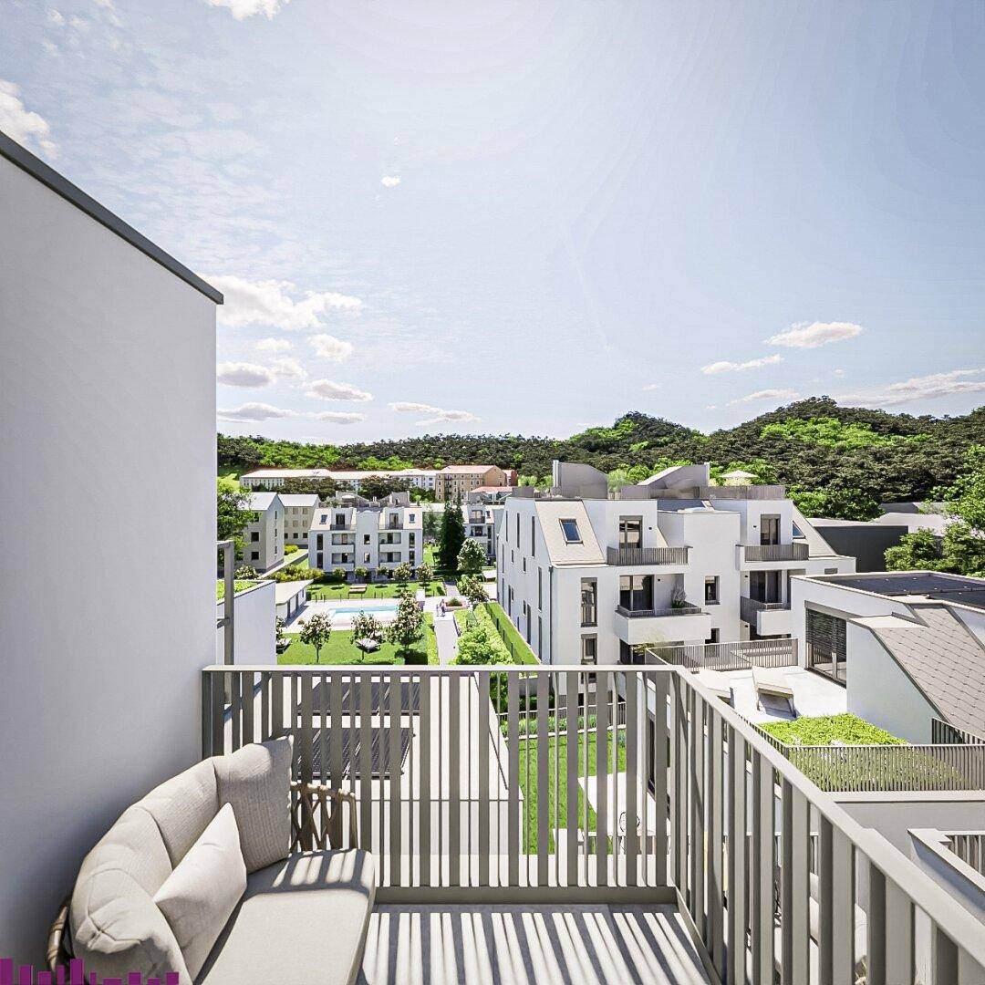 Moderner Balkon mit bequemen Sitzgelegenheiten und Blick auf die grüne Wohnanlage.