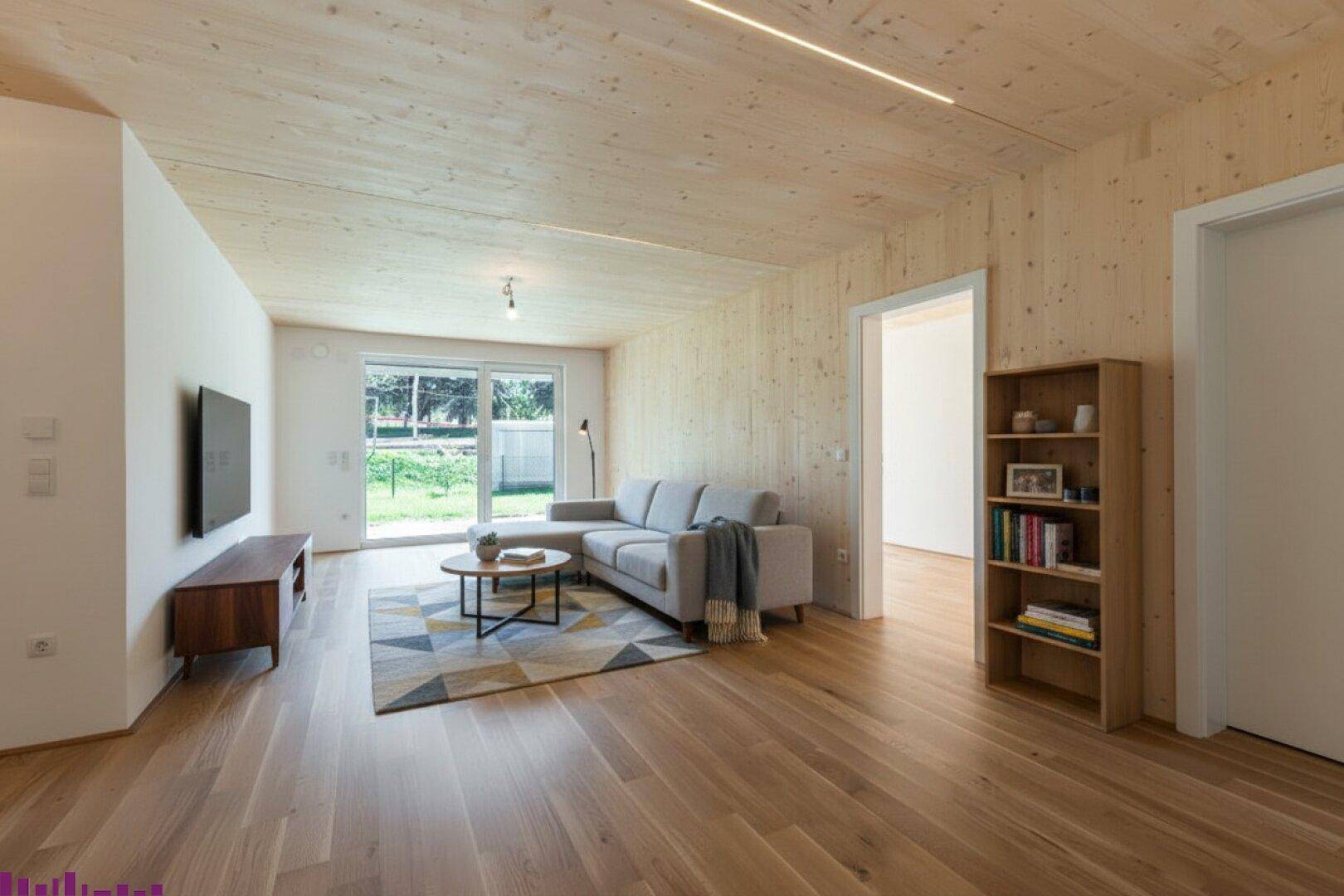Modern eingerichtetes Wohnzimmer mit Holzboden, Holzwänden und Zugang zu einem Außenbereich.