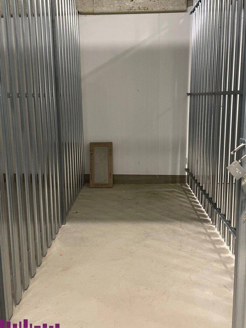 Geräumiger Abstellraum im Keller mit Metallabtrennungen und Betonboden.