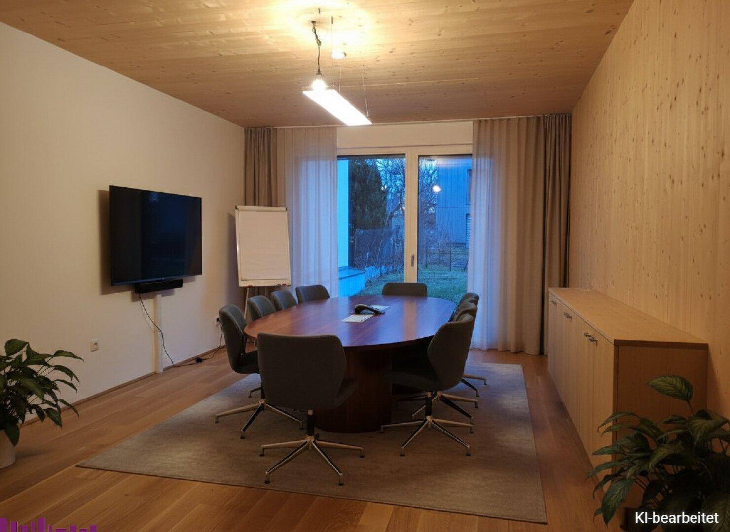 Moderner Konferenzraum mit Holzwänden, großem Tisch, TV und Blick ins Freie.