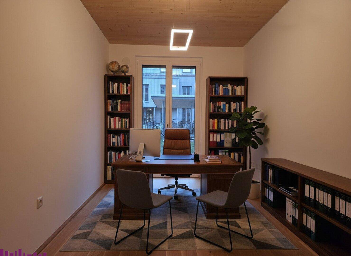 Helles Büro mit Holzboden, Bücherregalen und Blick ins Grüne durch große Fenster.