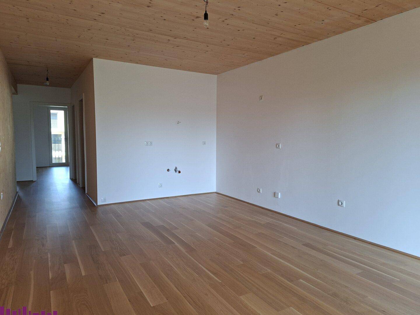 Geräumiger, heller Raum mit Holzboden und Holzdecke, bereit für die Einrichtung.