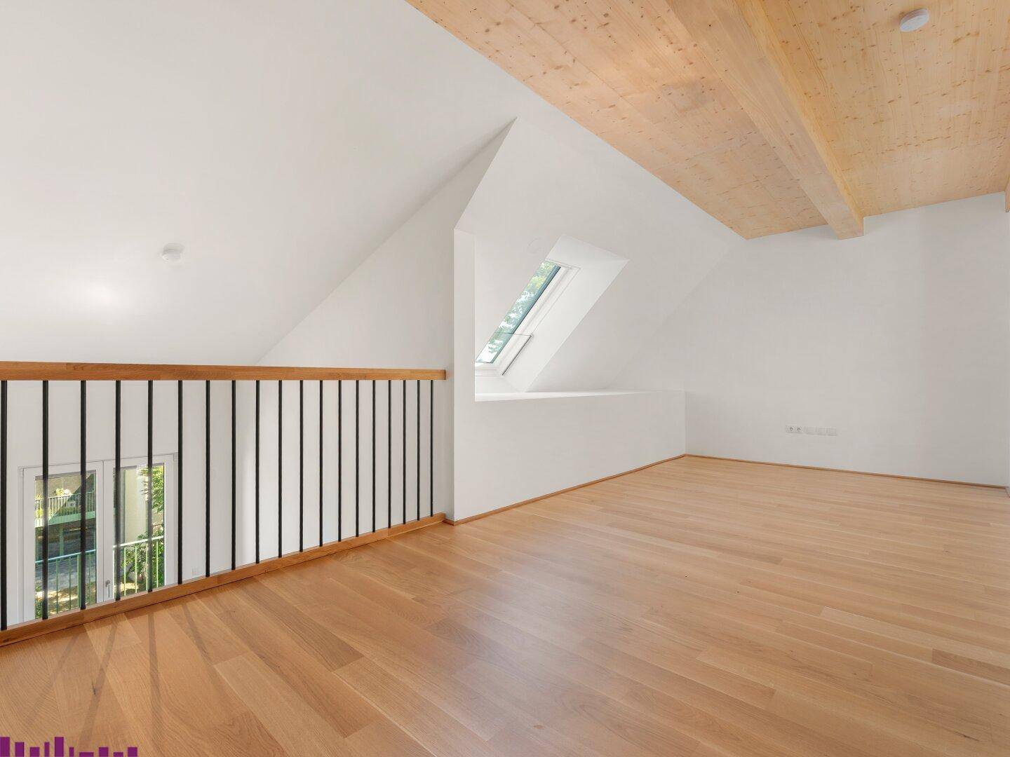 Heller Dachbodenraum mit Holzbalkendecke, Parkettboden und Dachfenster, ideal für offenes Wohnen.