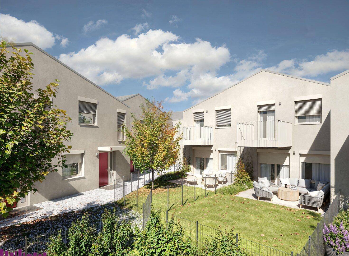 Moderne Reihenhäuser mit privaten Gärten und möblierten Terrassen unter blauem Himmel.