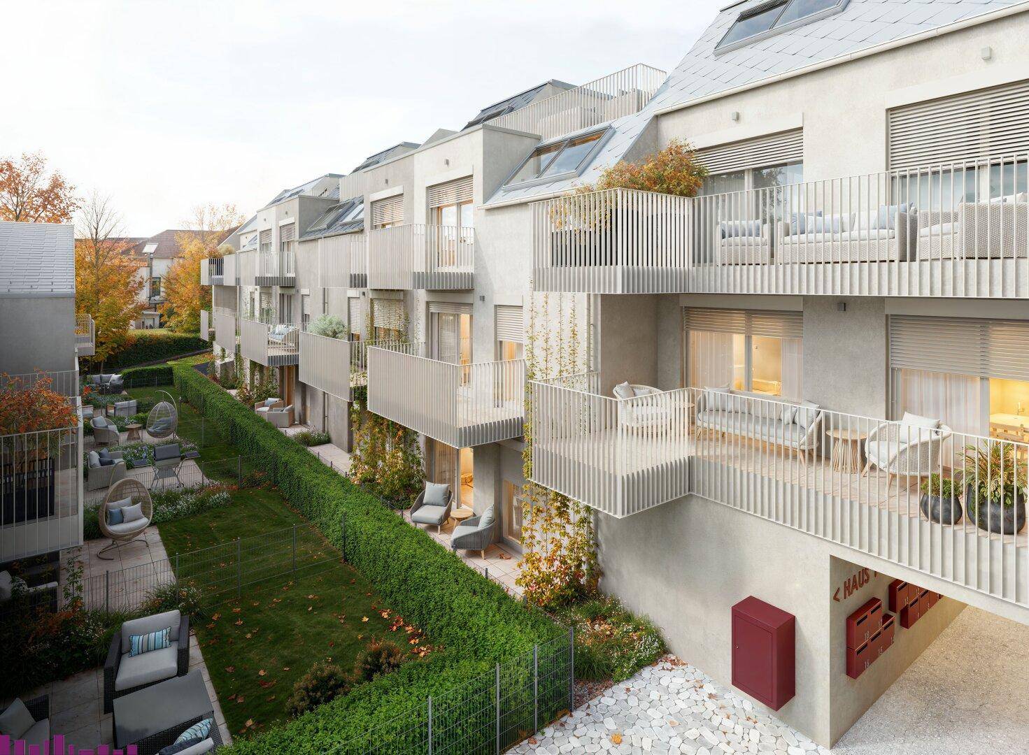 Reihen moderner Wohnungen mit Balkonen, Terrassen und gepflegten Gärten von oben betrachtet.