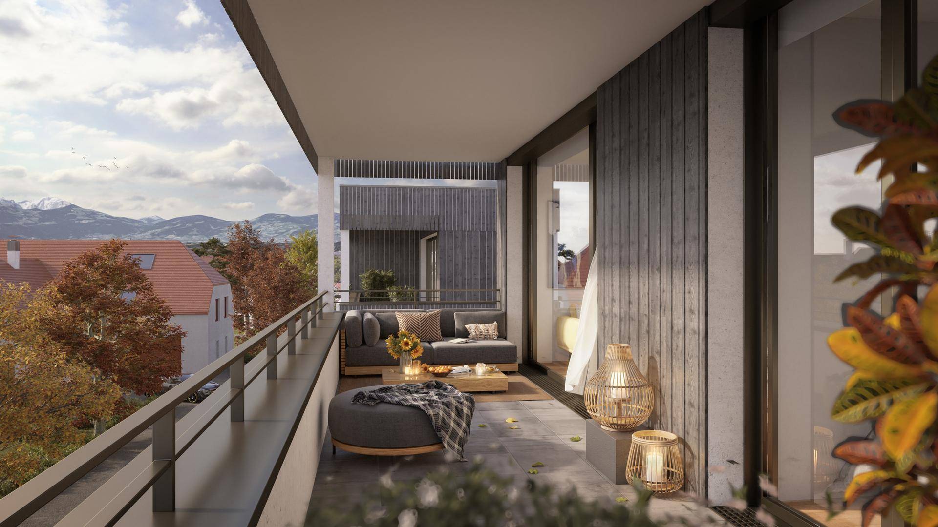 Geräumiger Balkon mit gemütlichen Loungemöbeln und Blick auf die umliegende Landschaft und Berge.
