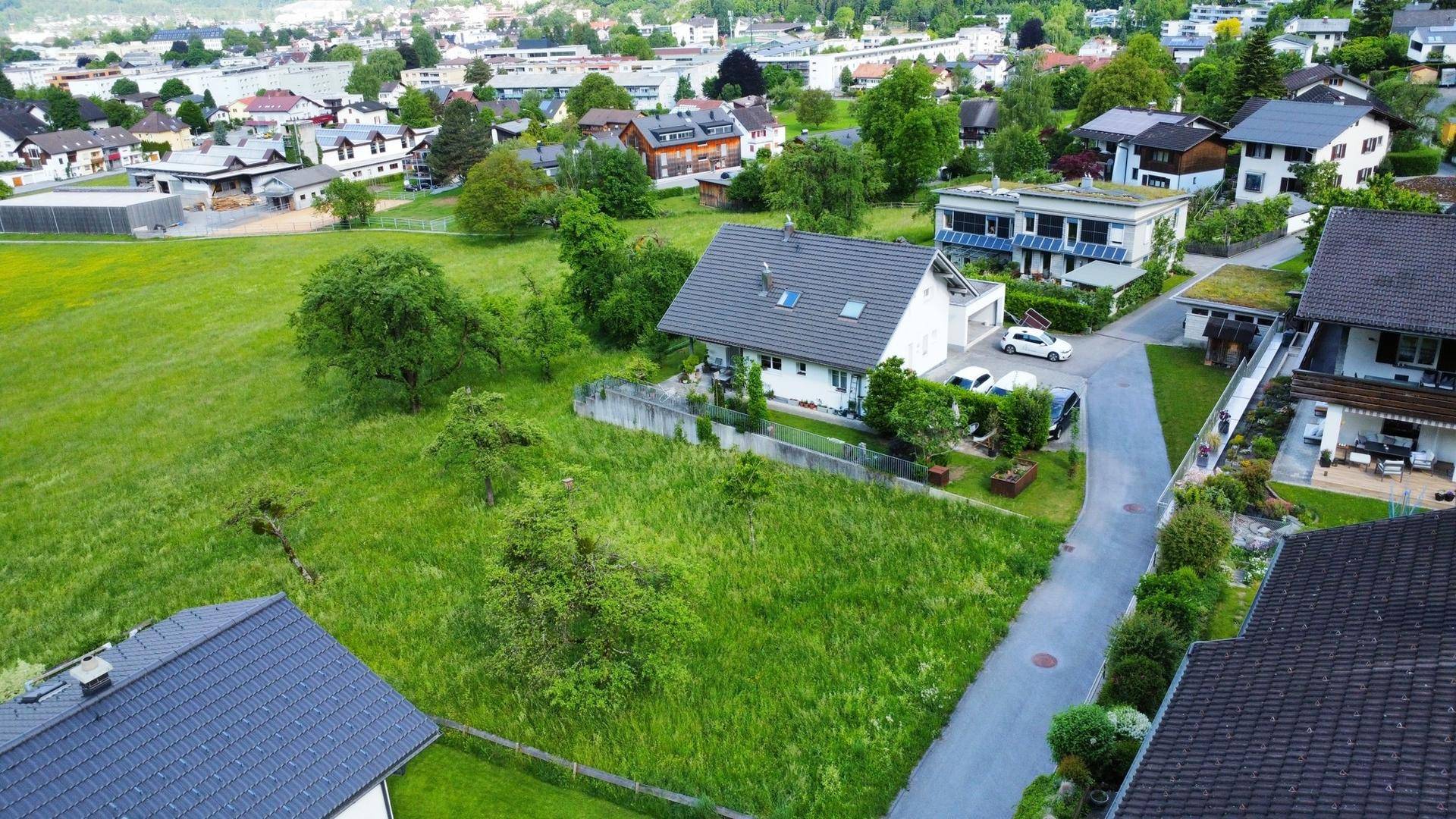 Panoramablick auf das Grundstück und die umliegende Wohngegend mit viel Grün und weiteren Häusern.
