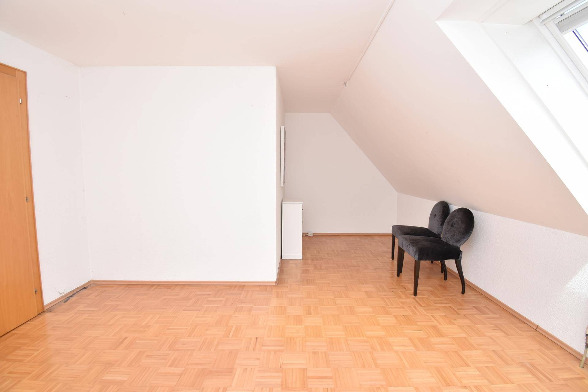 Geräumiges Schlafzimmer mit Parkettboden, Dachschräge und viel Potenzial.