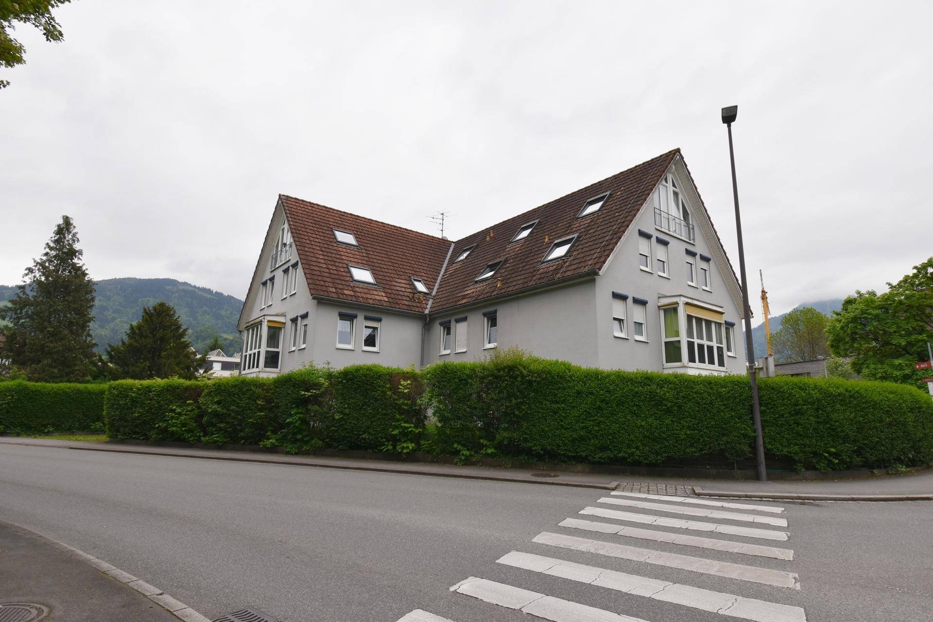 Ansicht des Gebäudes von der Straße mit Satteldach und vielen Dachfenstern.