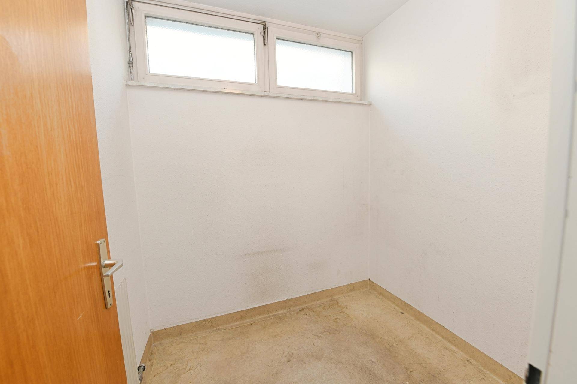 Kleiner Abstellraum mit Fenster und Betonboden, bietet zusätzlichen Stauraum.