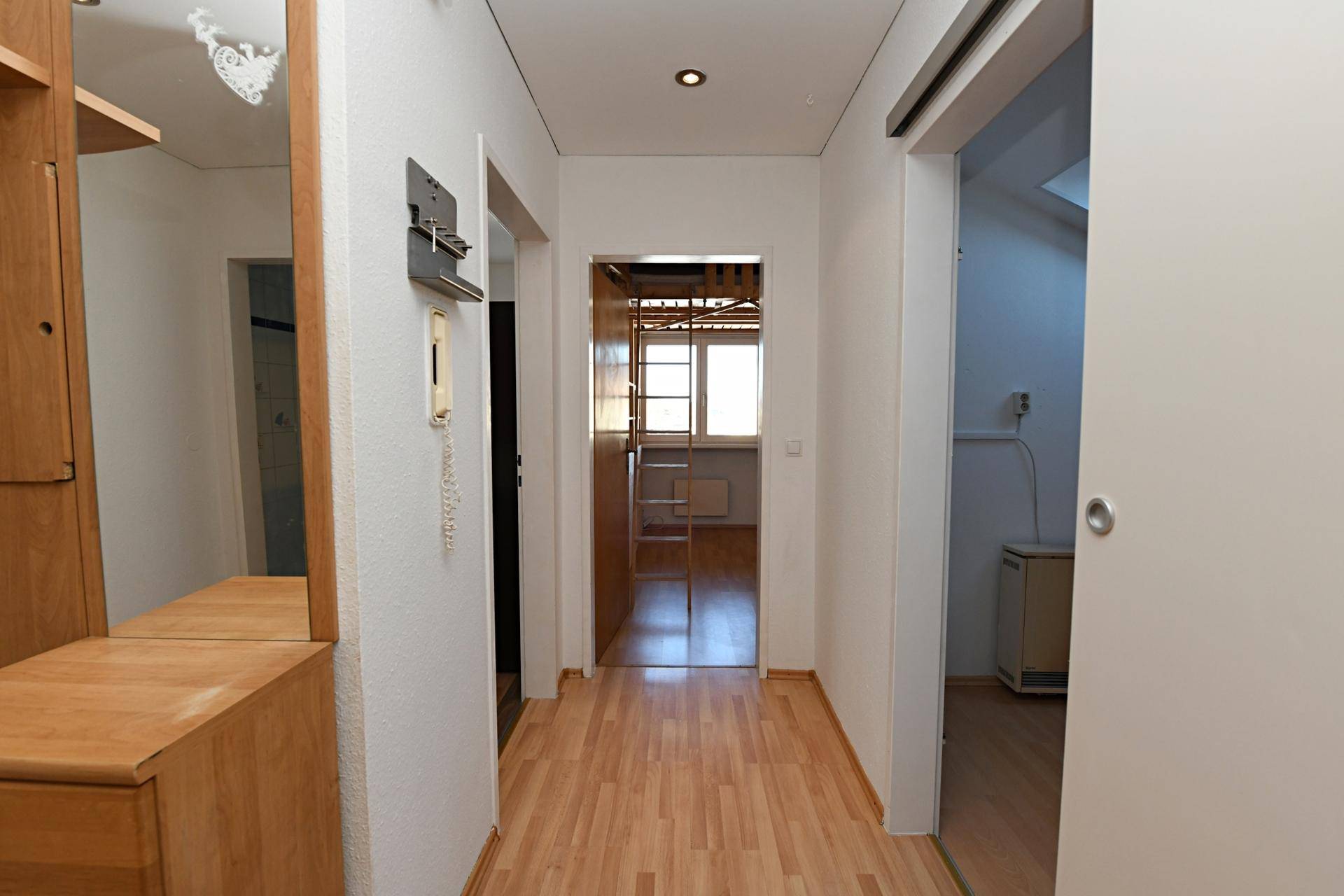 Heller Flur mit Laminatboden und Zugang zu weiteren Zimmern der Wohnung.