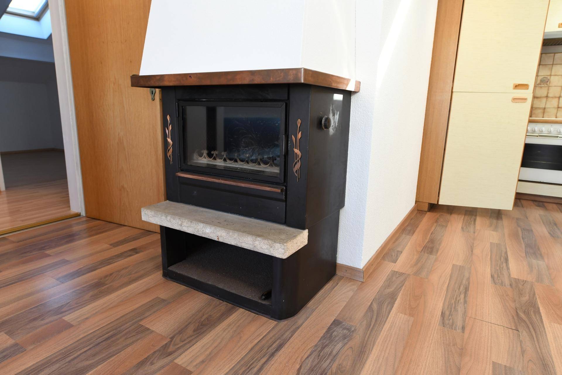 Detailansicht des Kamins im Wohnbereich mit Holzboden und rustikalem Charme.