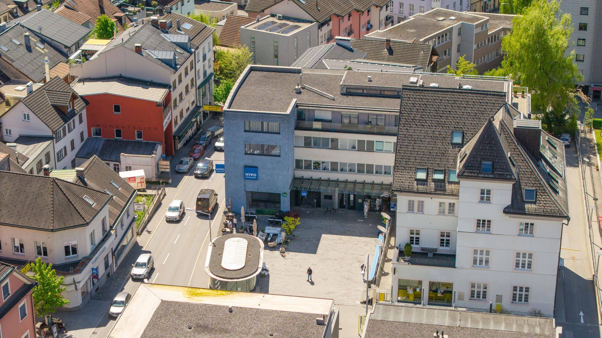 Luftaufnahme eines Stadtviertels mit verschiedenen Gebäuden und Straßen.