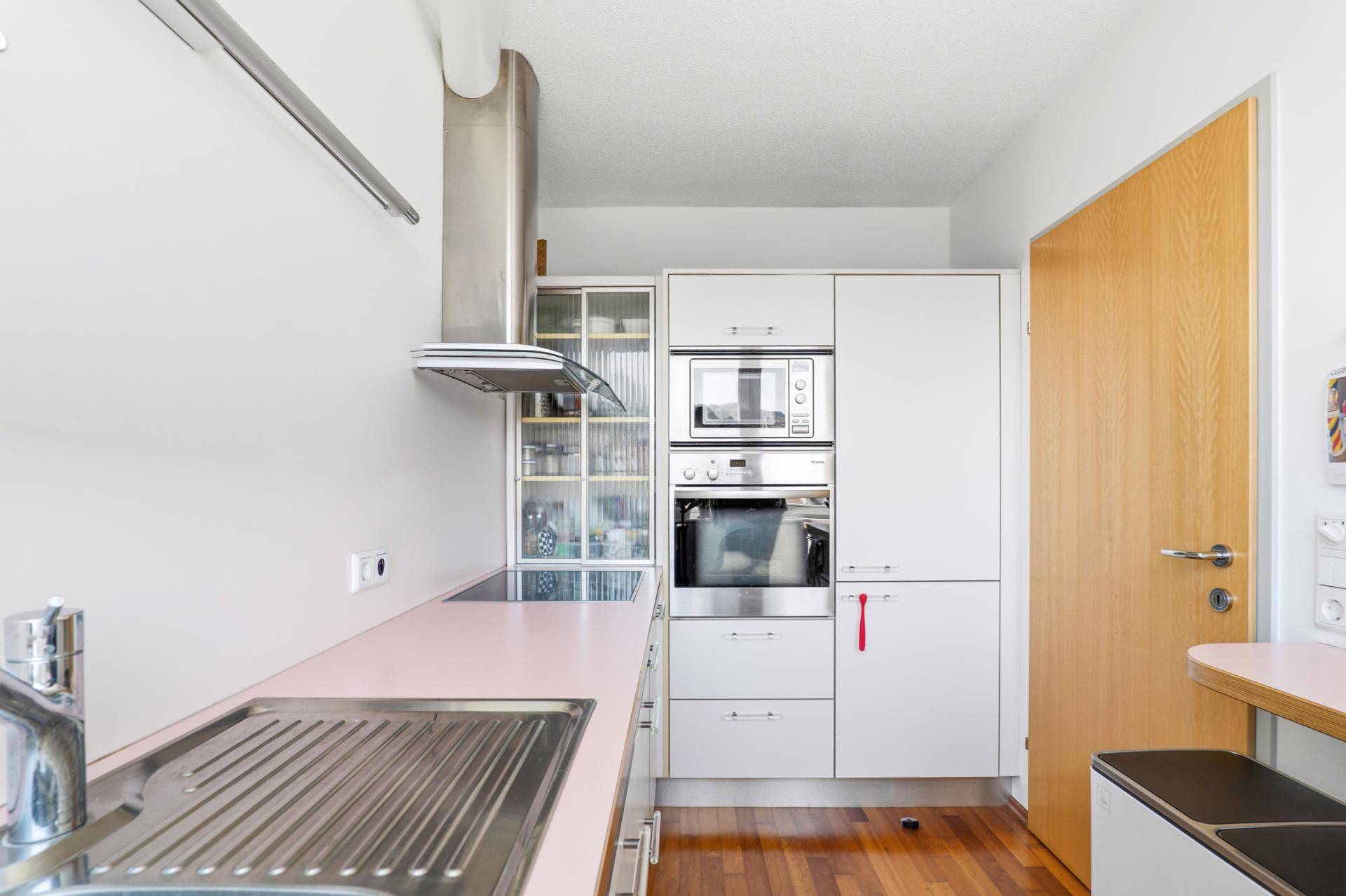 Moderne Küche mit Einbaugeräten, Dunstabzugshaube und ausreichend Stauraum.