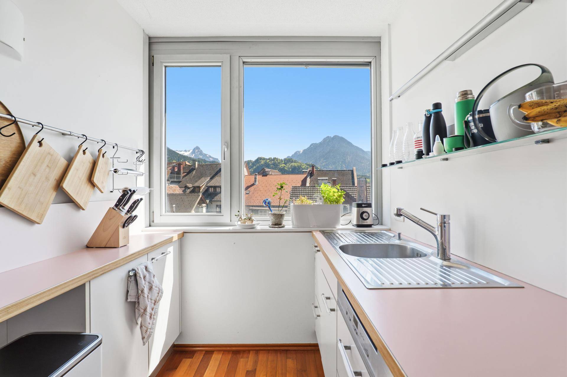 Funktionale Küche mit Fenster und Bergblick, ausgestattet mit Spüle und Arbeitsflächen.