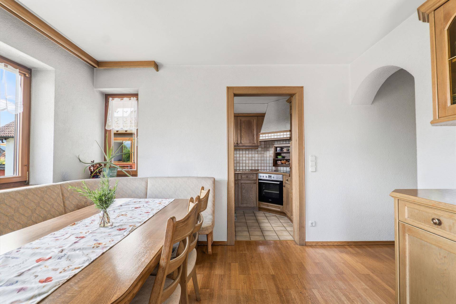 Essbereich mit Holztisch und Blick in die angrenzende Küche.