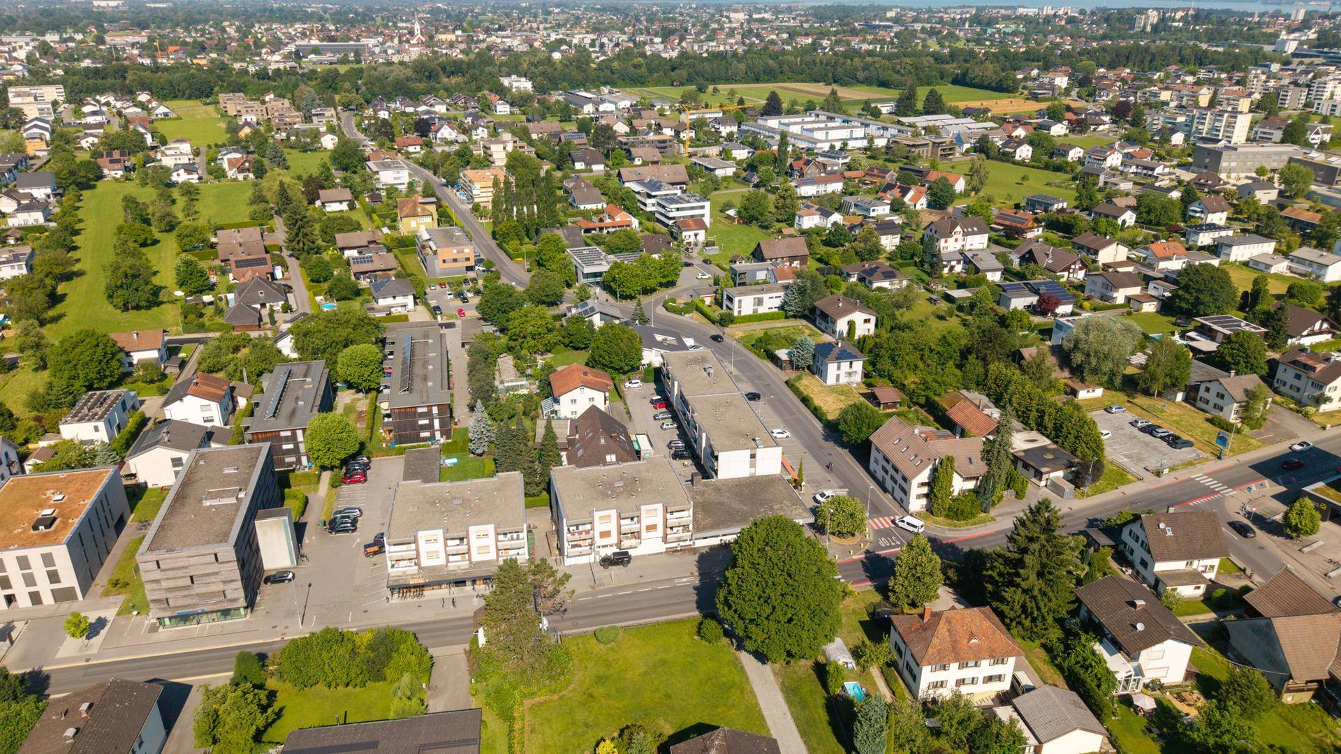 Übersichtliche Luftaufnahme einer weitläufigen Wohngegend mit vielen Einfamilienhäusern und Grünflächen.