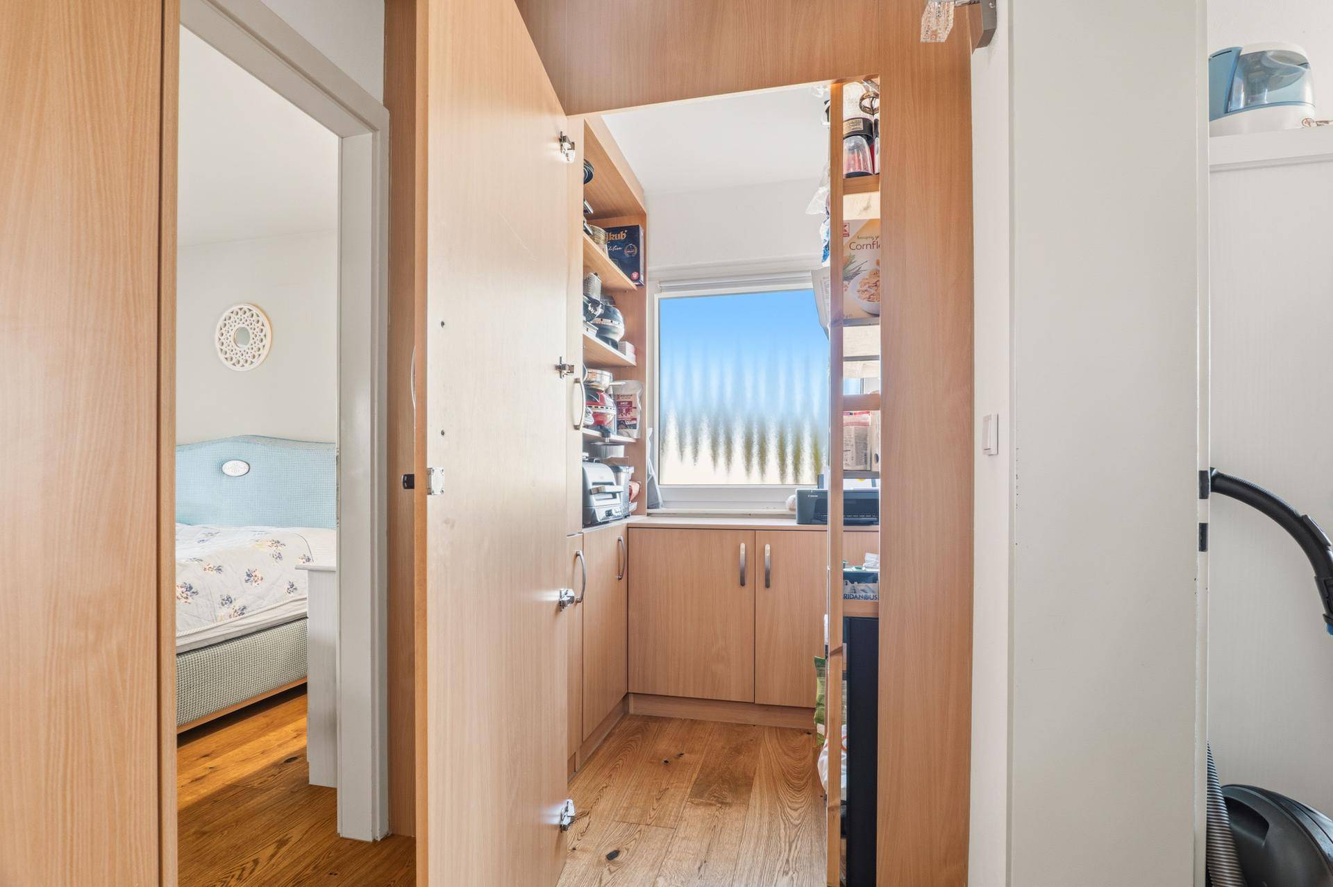 Praktische Speisekammer mit Regalen, Schränken und Fenster.