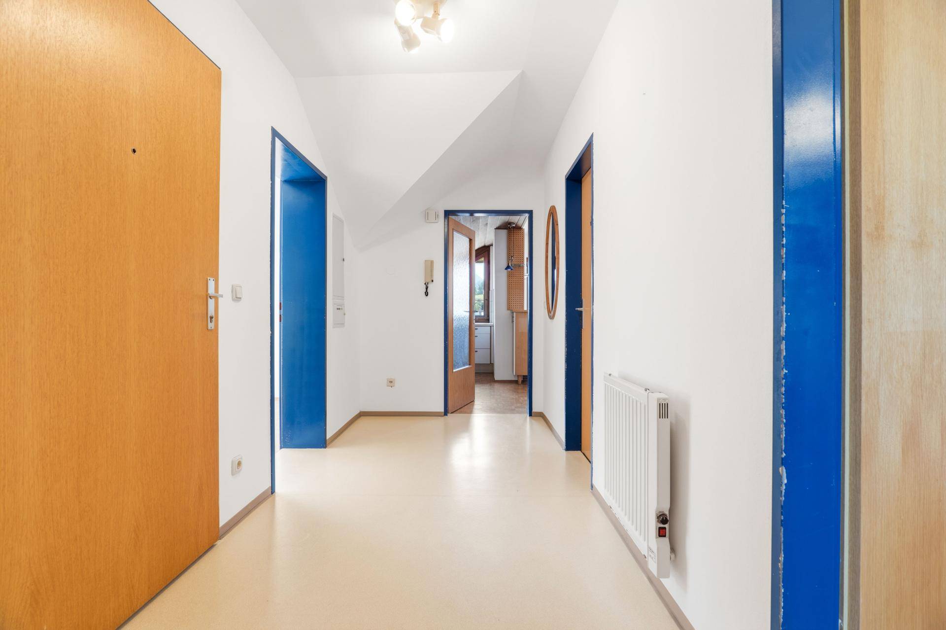 Geräumiger Flur mit hellem Boden, weißen Wänden und Zugang zu verschiedenen Räumen.